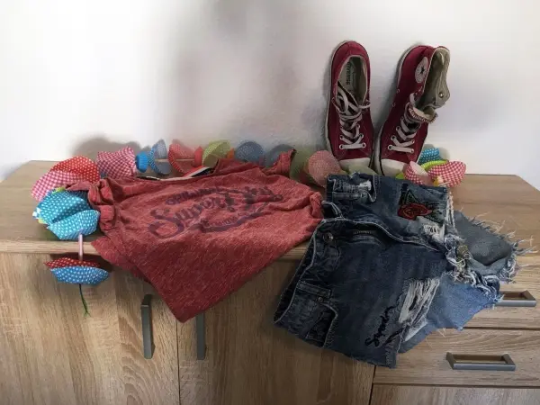 Mit knöchelhohen Chucks, einem Print-Shirt und Ripped Shorts kann man ein lässiges Grunge-Outfit zusammenstellen.