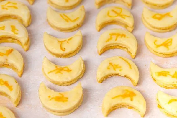Orangenplätzchen mit Orangenschale verziert, dürfen auf keinem Plätzchenteller fehlen. Saftige Orangenkekse in Halbmondform mit frischer Orangenschale – so backst Du fruchtige Plätzchen.