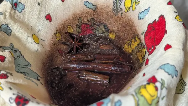 Eine Schüssel nehmen, ein Sieb draufstellen, mit einem Mulltuch auskleiden und den Bratapfellikör filtern. Eine Schüssel nehmen, ein Sieb draufstellen, mit einem Mulltuch auskleiden und den Bratapfellikör filtern.