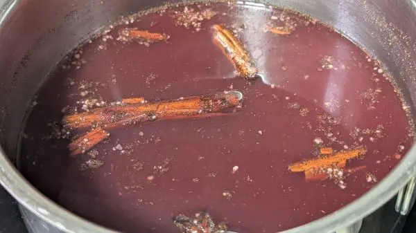 Roter Bratapfellikör kochen: Nach dem Köcheln und Ziehenlassen den Rum zufügen und umrühren. Roter Bratapfellikör kochen: Nach dem Köcheln und Ziehenlassen den Rum zufügen und umrühren.
