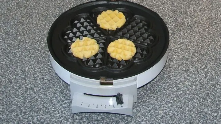 Maximal 3 Teigbällchen auf der Backfläche verteilen, Eisen schließen und kräftig drücken. Etwa 2-3 Minuten, (kann kürzer sein, wenn euer Eisen heißer ist) backen.