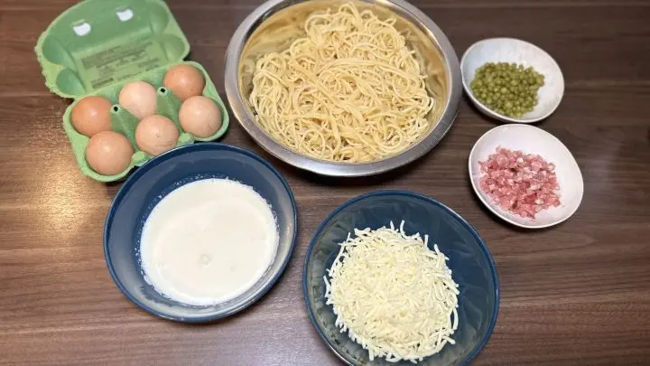 Zuerst richtest du alle Zutaten her, die du brauchst. Also Eier, Sahne, Käse, gekochte Spaghetti, Erbsen und falls du magst auch Schinkenwürfel. Bereite köstliche Spaghetti-Muffins zu: Die Zutaten sind einfach – Spaghetti, Eier, Sahne, Käse, Erbsen und Schinken. Perfekt als Snack oder Partyidee. Der Artikel zeigt Dir, wie du diese Leckerei ganz leicht selbst machen kannst.