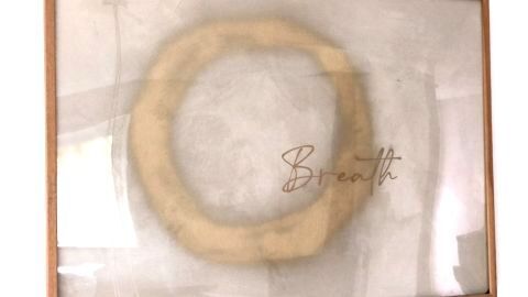 Gerahmtes Bild zeigt stilisierten Kreisen in Gold, darüber steht in eleganter Schrift "Breath", betont Upcycling-DIY.