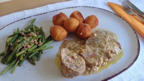 Ein kulinarisches Highlight: Zartes Schweinefilet in Senf-Sahne-Soße serviert mit knusprigen Kartoffelbällchen und aromatischen grünen Bohnen. Hol' dir ein Stück Genuss mit diesem einfachen Rezept.