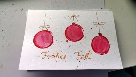 Gestalte Weihnachtskarten selbst. Diese handgemalte Karte mit roten Kugeln und der Aufschrift "Frohes Fest" inspiriert kreative Ideen für die festliche Jahreszeit.