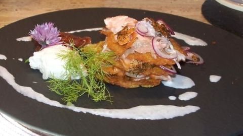 Kartoffelpuffer trifft auf geräucherten Lachs und Meerrettichschaum: Ein herzhaftes Gericht, das elegante Aromen vereint. Dieses Bild zeigt die kunstvolle Anrichtung und verlockende Texturen, die im Artikel beschrieben werden.